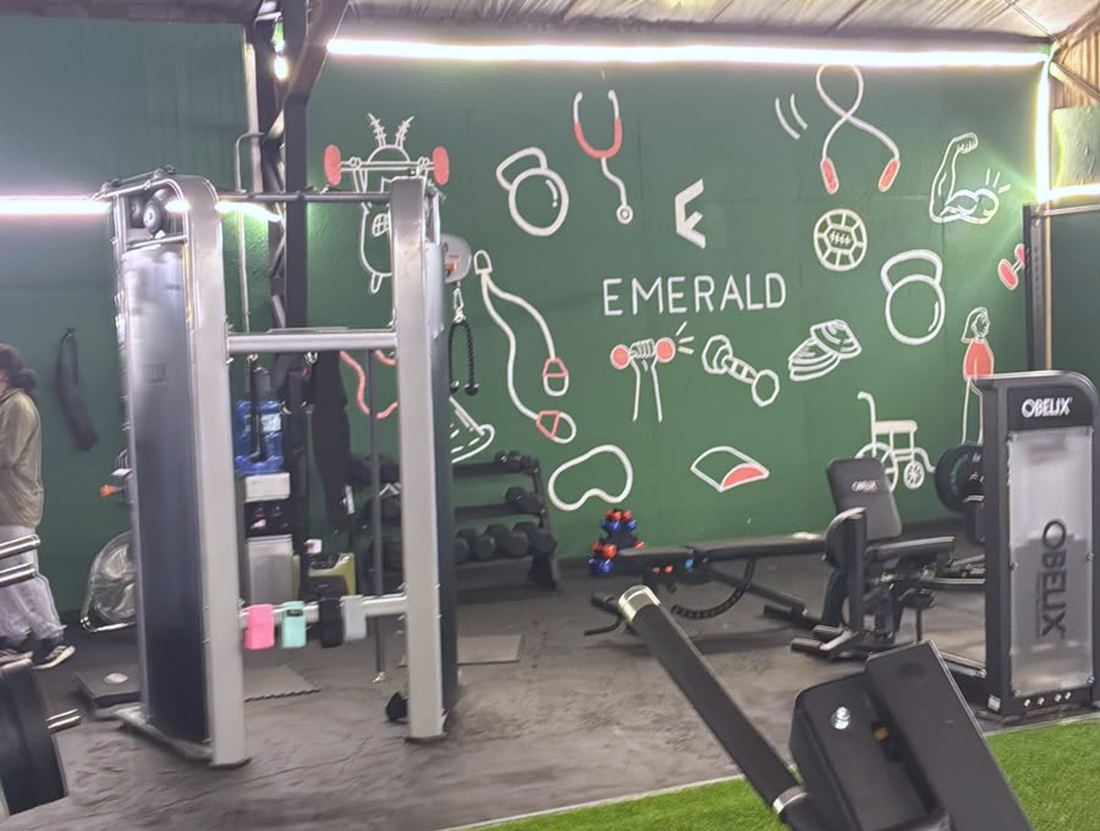 Sala de EMERALD con máquinas y el mural del muro verde